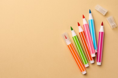 Photo of Many bright markers on beige background, flat lay. Space for text