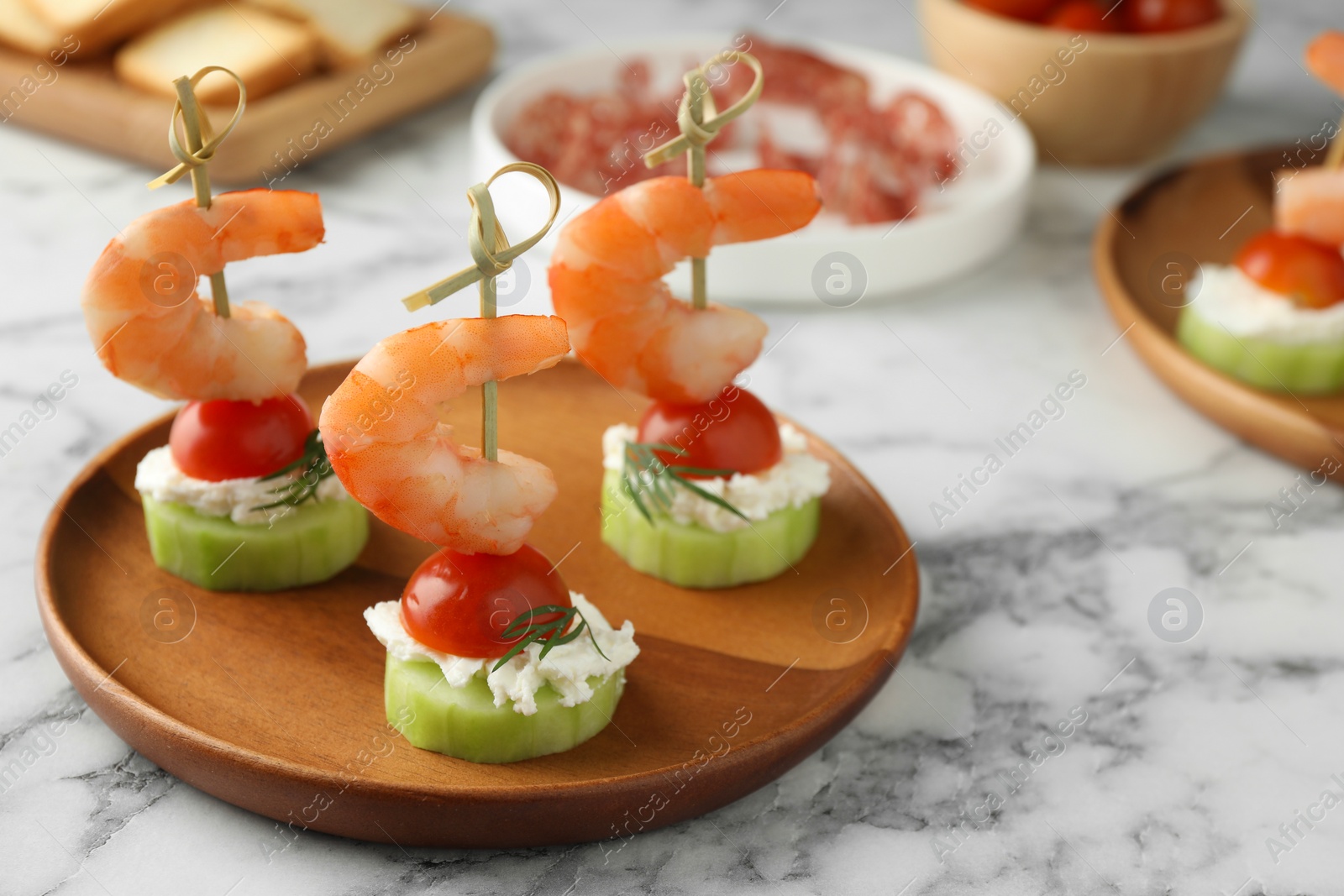 Photo of Tasty canapes with shrimps, vegetables and cream cheese on white marble table