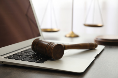 Laptop, gavel and scales on table, closeup. Cyber crime