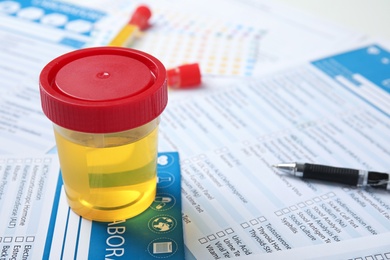 Container with urine sample for analysis on test form