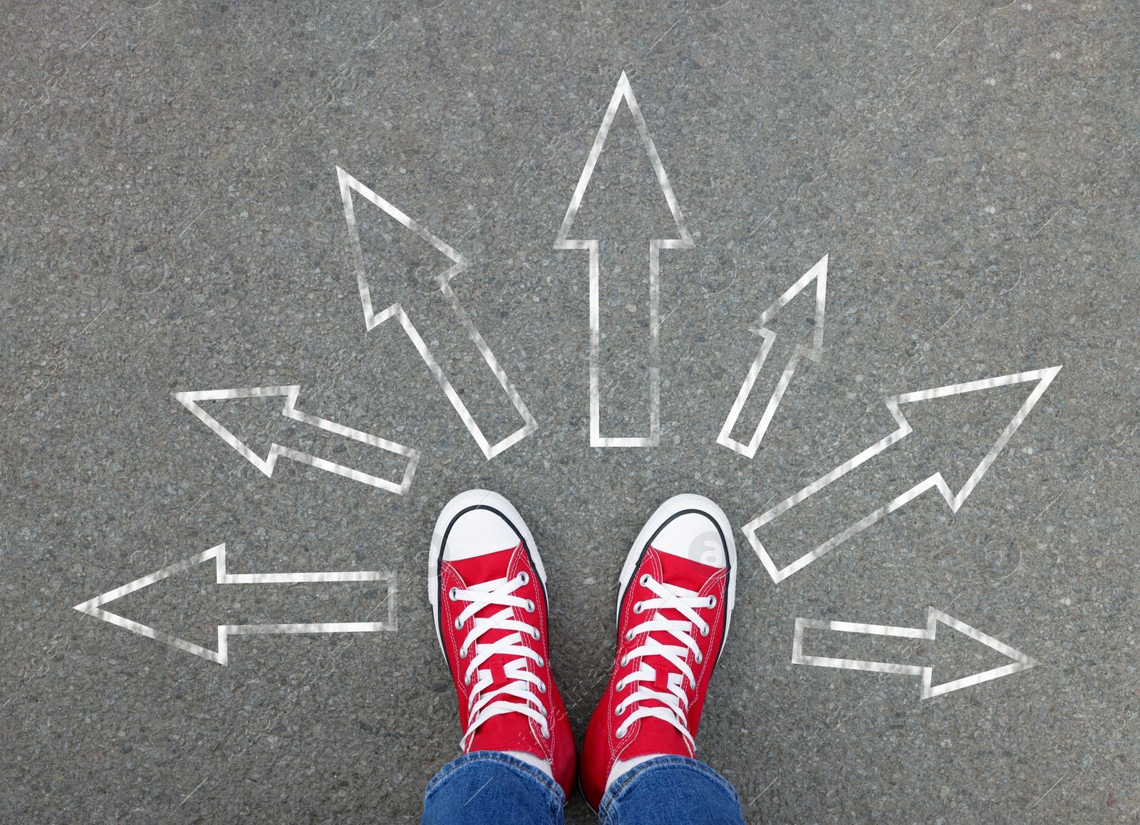 Image of Choosing future profession. Girl standing in front of drawn signs on asphalt, top view. Arrows pointing in different directions as diversity of opportunities