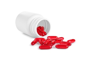 Photo of Plastic medical bottle with many red pills isolated on white