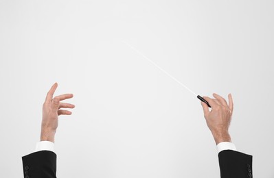 Professional conductor with baton on white background, closeup