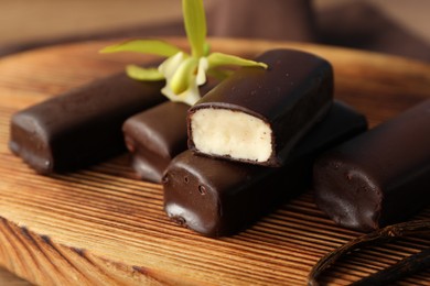 Photo of Glazed vanilla curd cheese bars served on wooden table, closeup