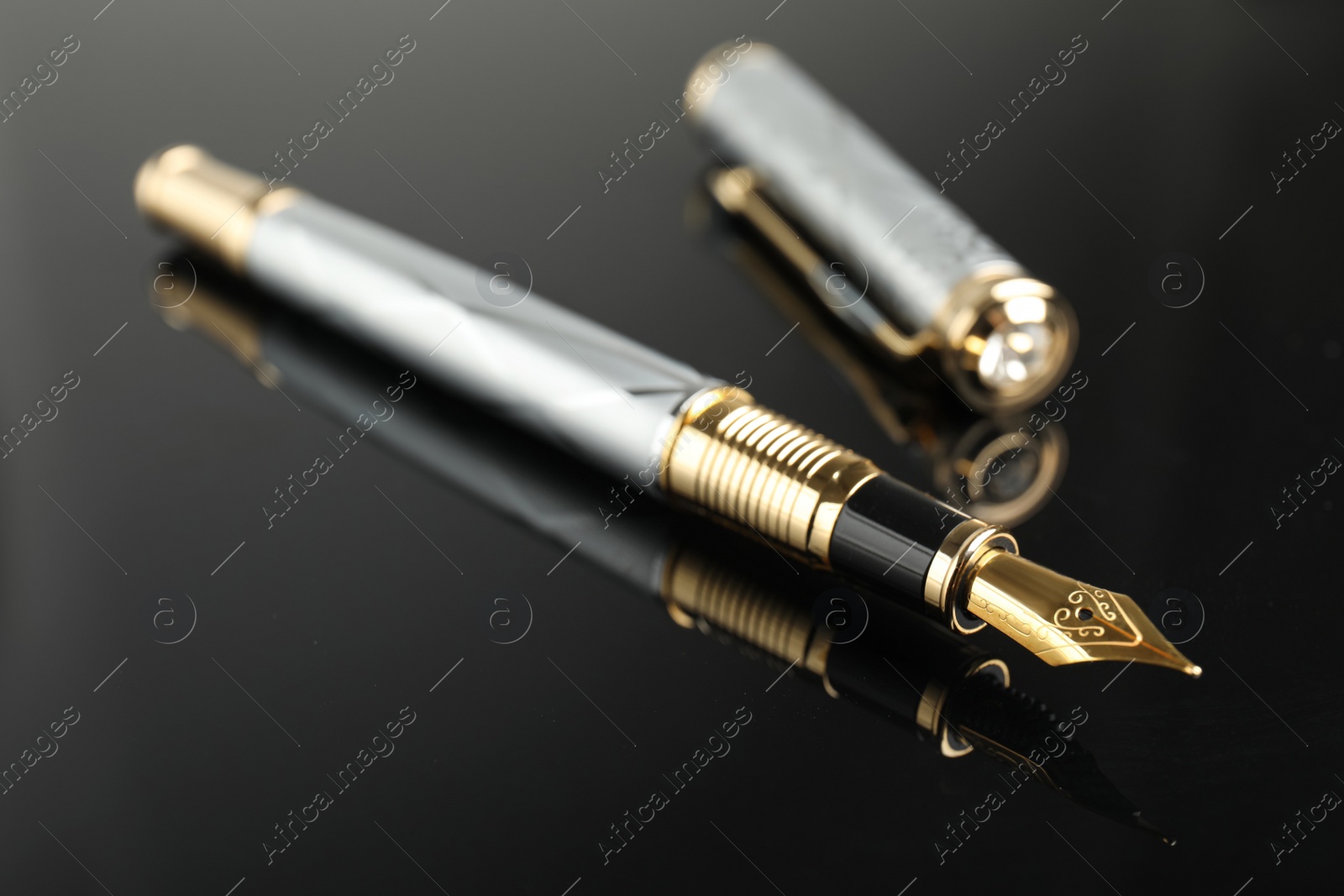 Photo of Beautiful fountain pen with ornate nib on black background, closeup
