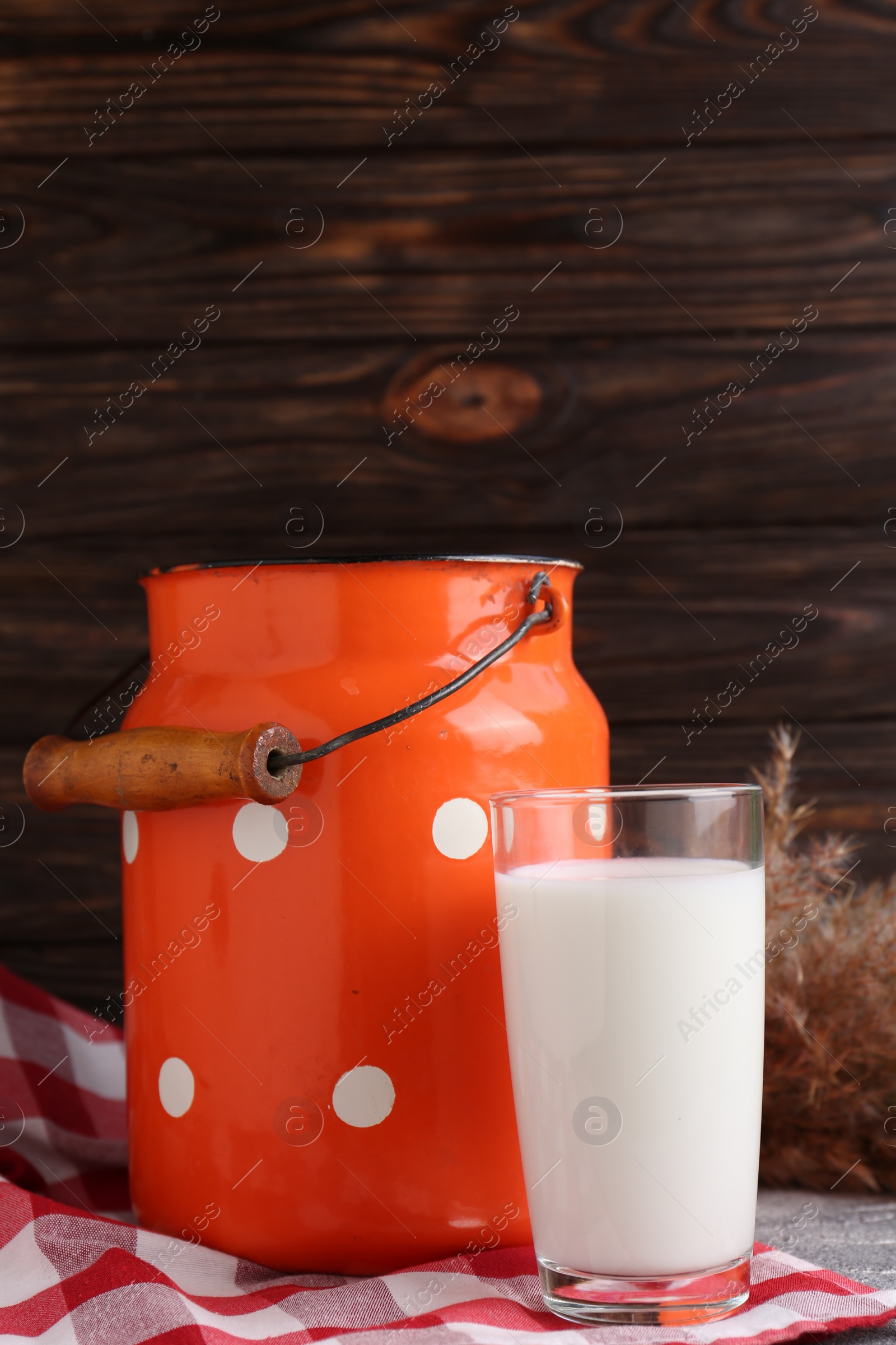 Photo of Can and glass of fresh milk on grey table