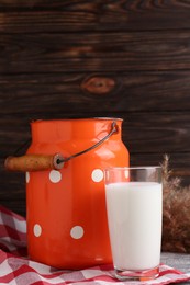 Can and glass of fresh milk on grey table