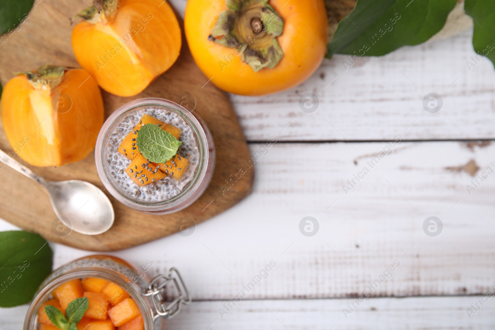 Photo of Delicious dessert with persimmon and chia seeds on table, flat lay. Space for text