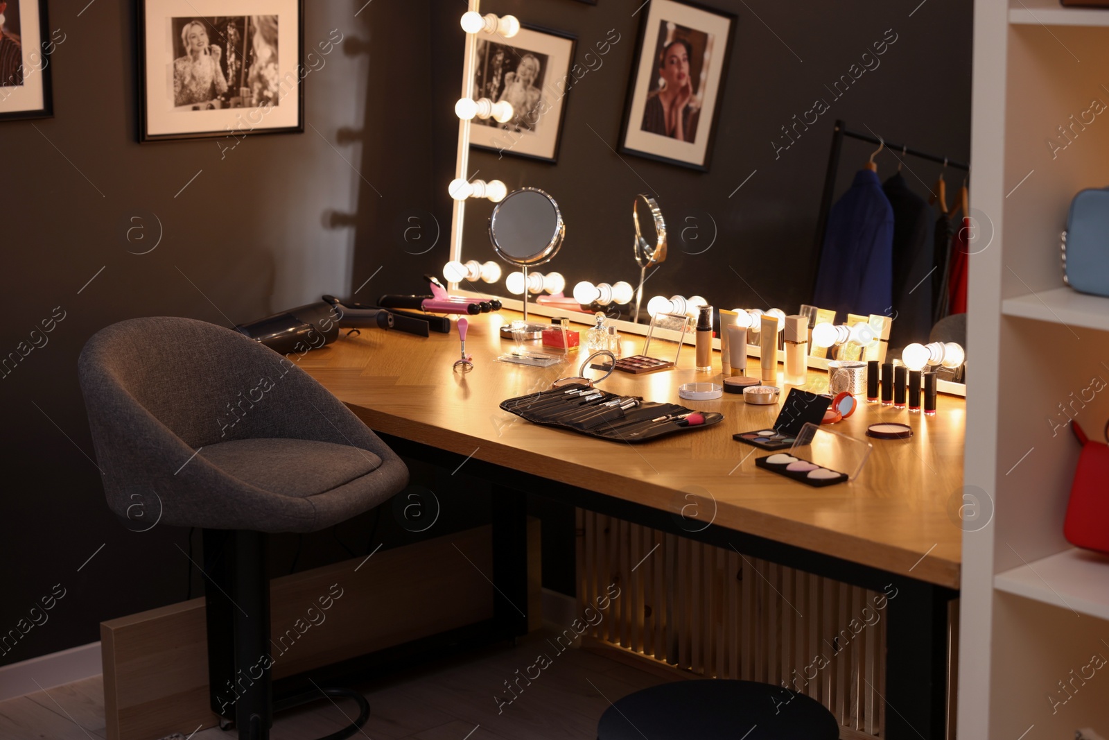 Photo of Makeup room. Stylish mirror on dressing table with different beauty products