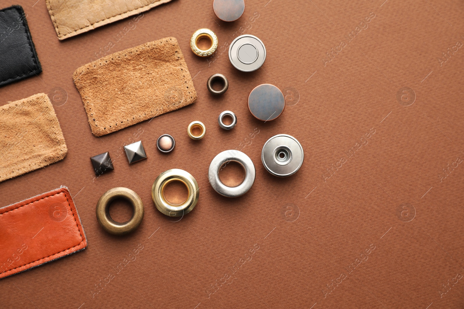 Photo of Flat lay composition with garment accessories for jeans on brown background