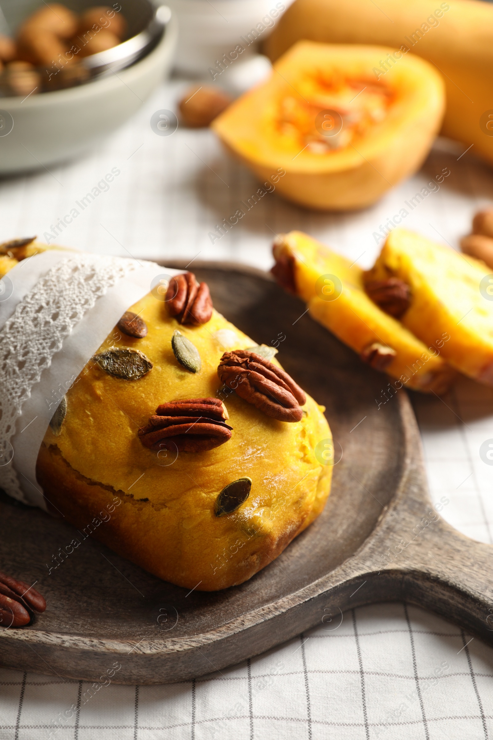 Photo of Delicious pumpkin bread with pecan nuts on tablecloth