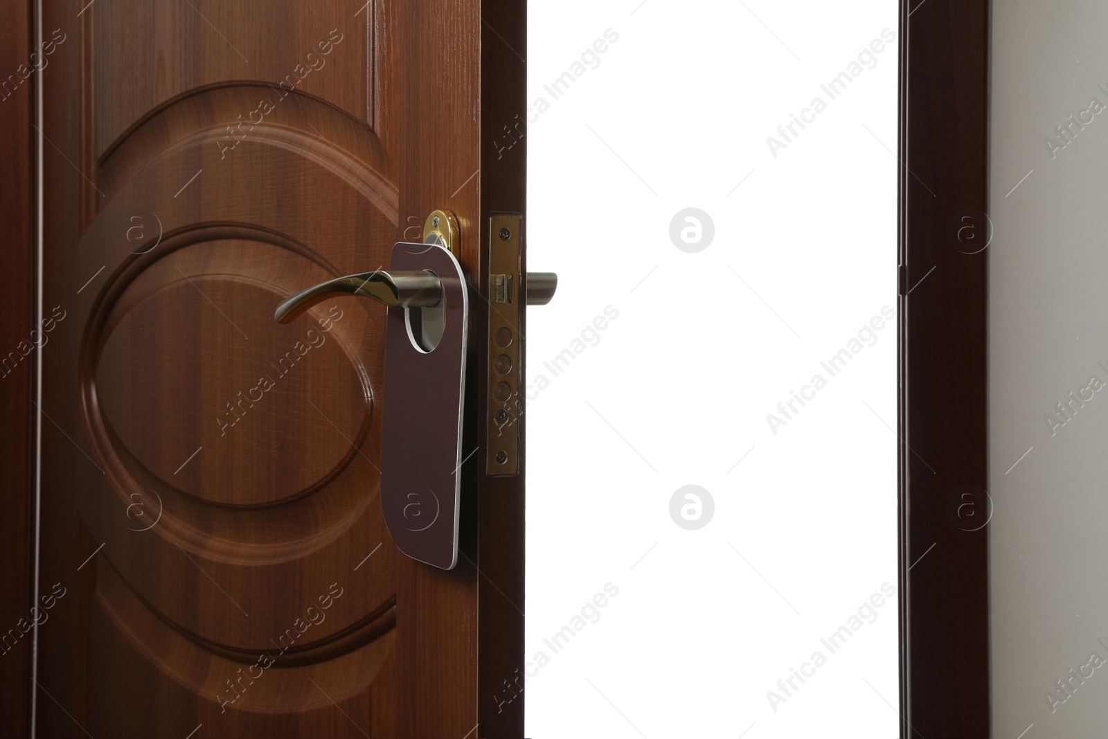 Photo of Hotel wooden door with blank hanger on white background, closeup