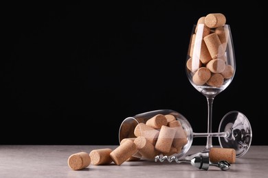 Glasses with wine corks and corkscrew on light table. Space for text