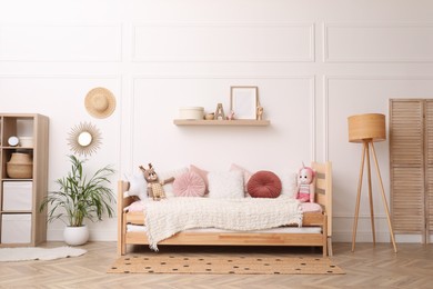 Cute child's room interior with comfortable bed and toys