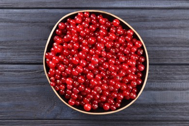 Ripe red currants in bowl on wooden rustic table, top view