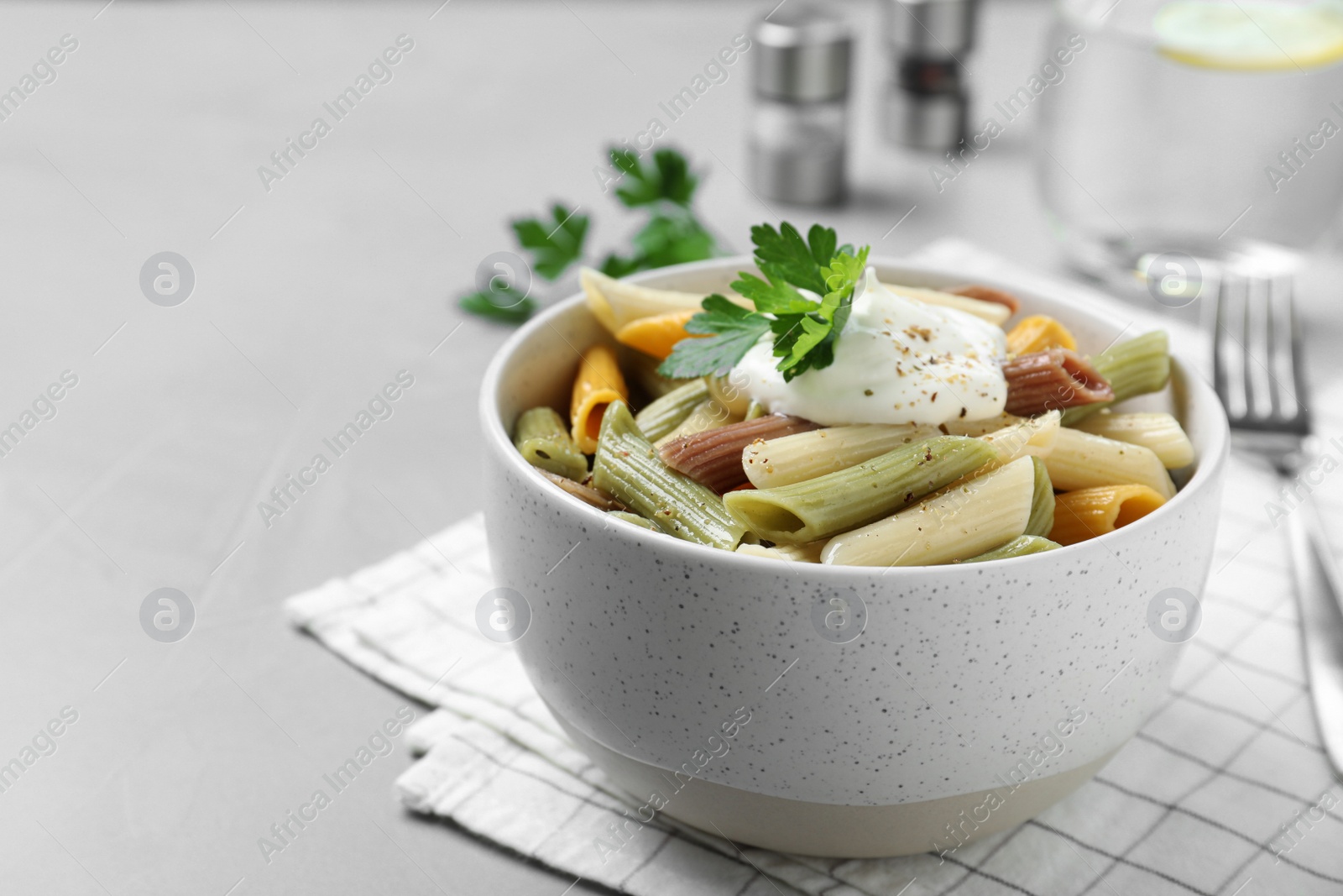 Photo of Delicious pasta with sour cream on light grey table