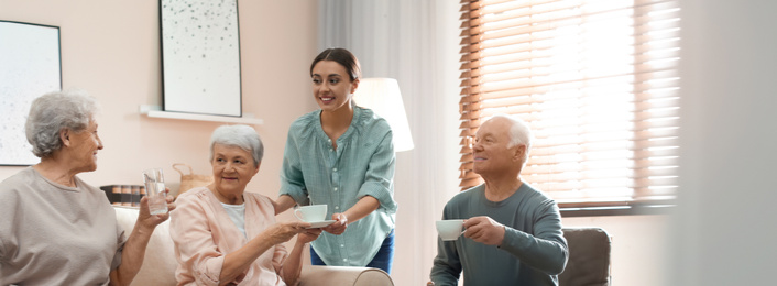 Image of Young woman taking care of elderly people in living room. Banner design
