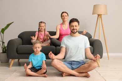 Family meditating together at home. Harmony and zen
