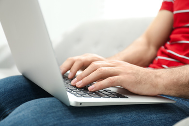 Photo of Man working on modern laptop at home, closeup
