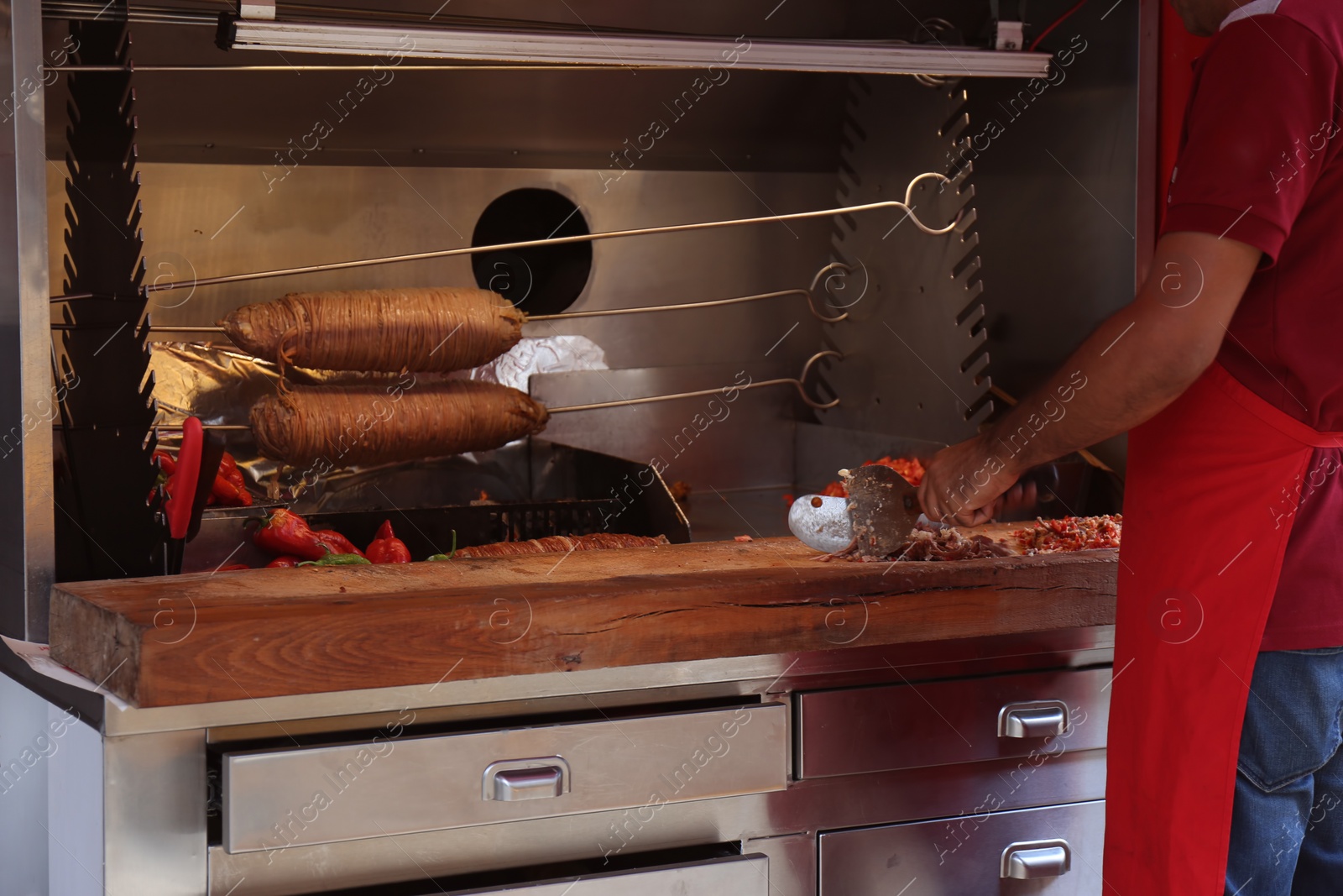 Photo of Man cooking delicious kokoretsi at table, closeup