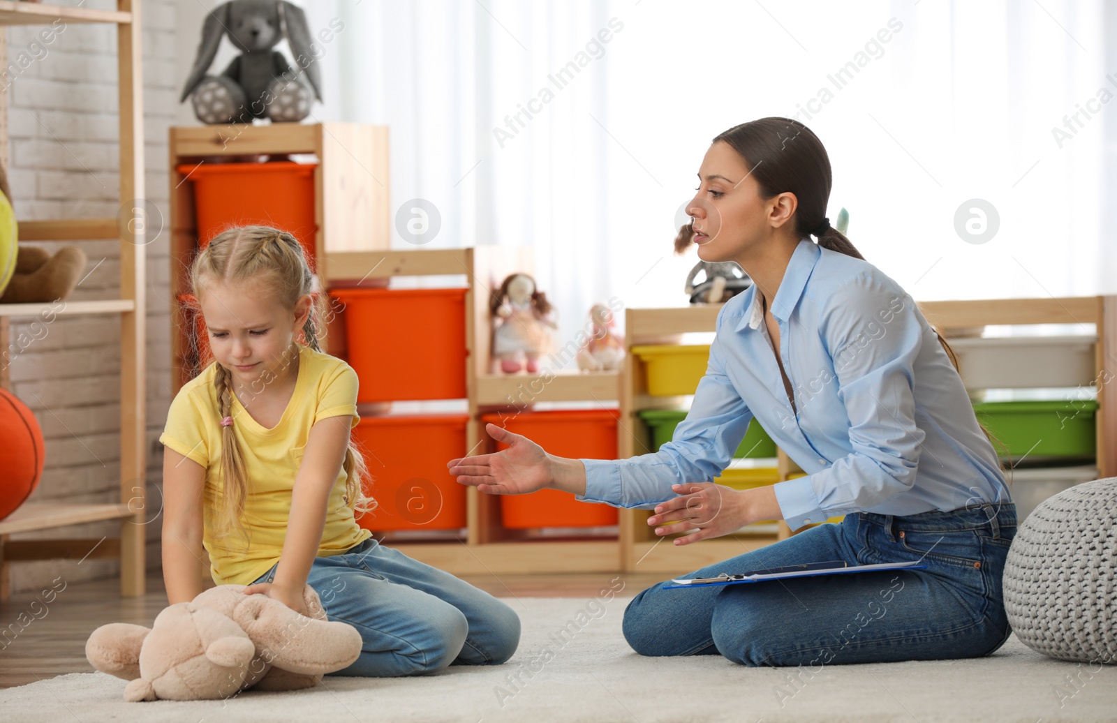 Photo of Child psychotherapist working with little girl in office