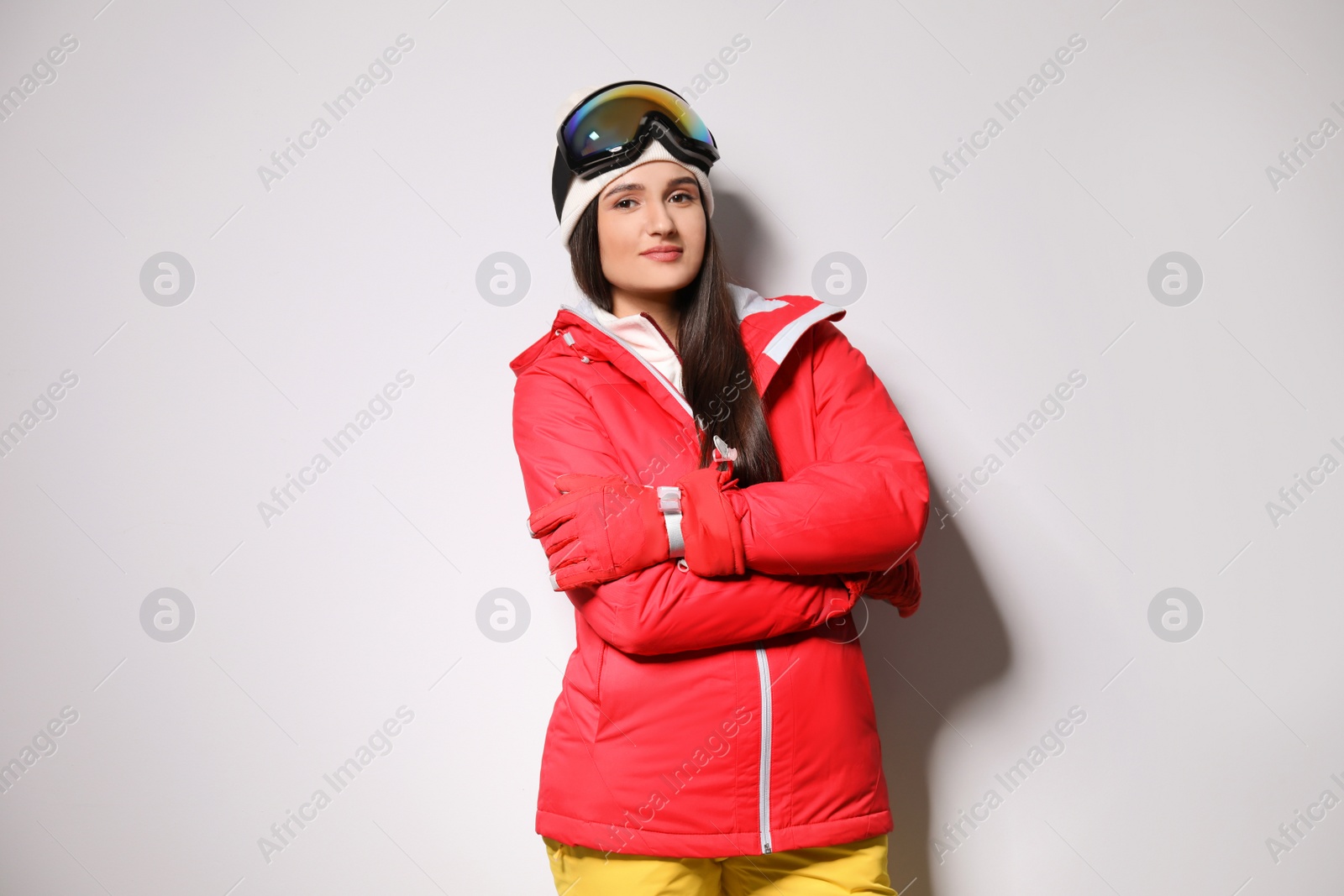 Photo of Woman wearing stylish winter sport clothes on light grey background