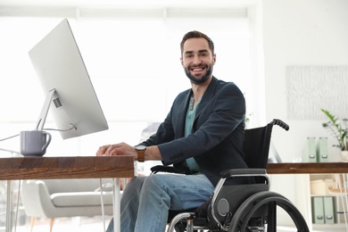 Portrait of young man in wheelchair at workplace