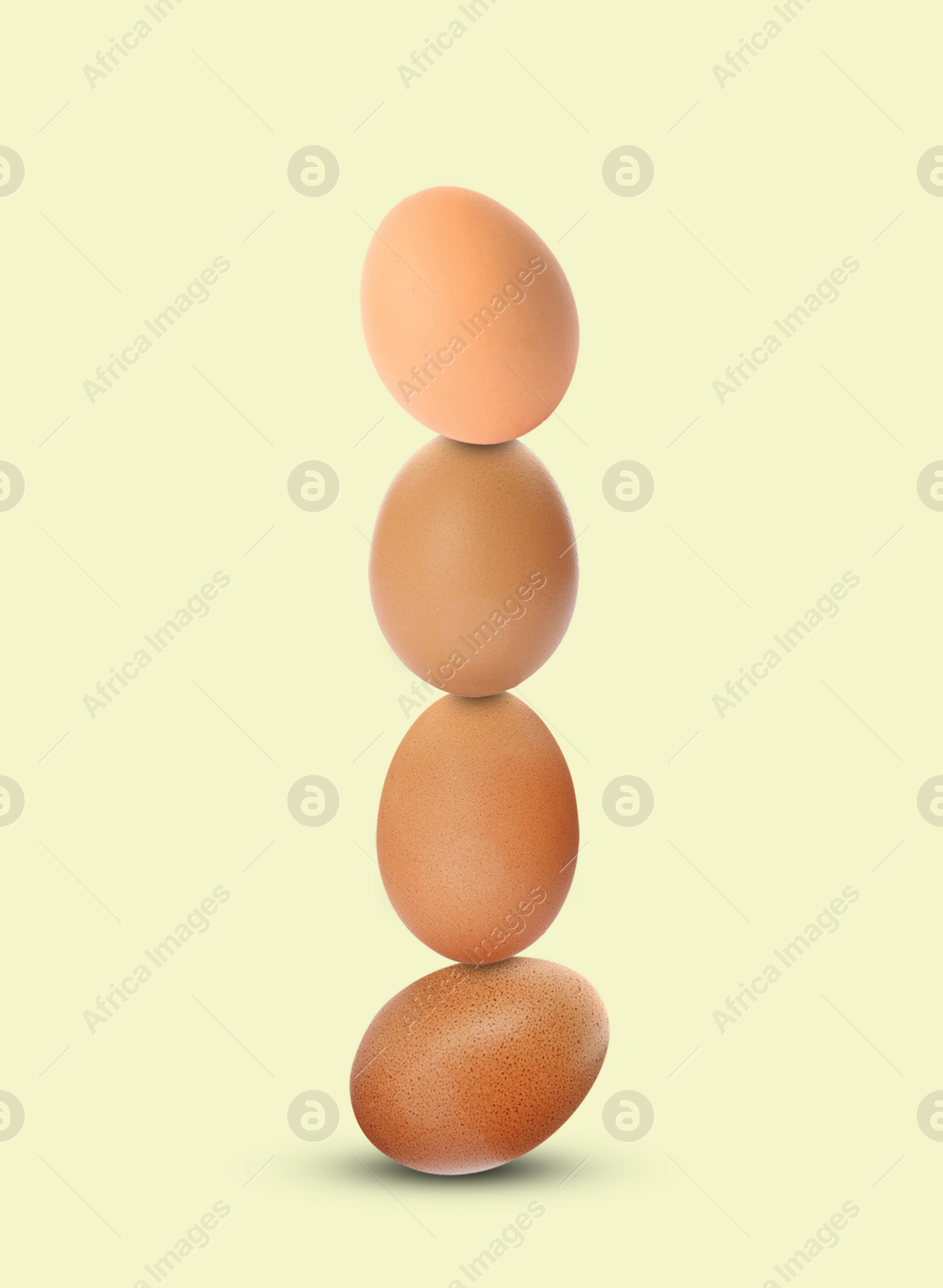 Image of Stacked fresh chicken eggs against light beige background