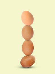 Image of Stacked fresh chicken eggs against light beige background