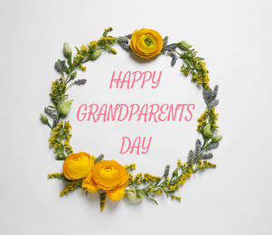 Image of Frame made of beautiful flowers and phrase HAPPY GRANDPARENTS DAY on white background, flat lay. Floral composition