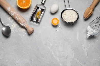 Flat lay composition with different tools for cooking on light grey marble table. Space for text