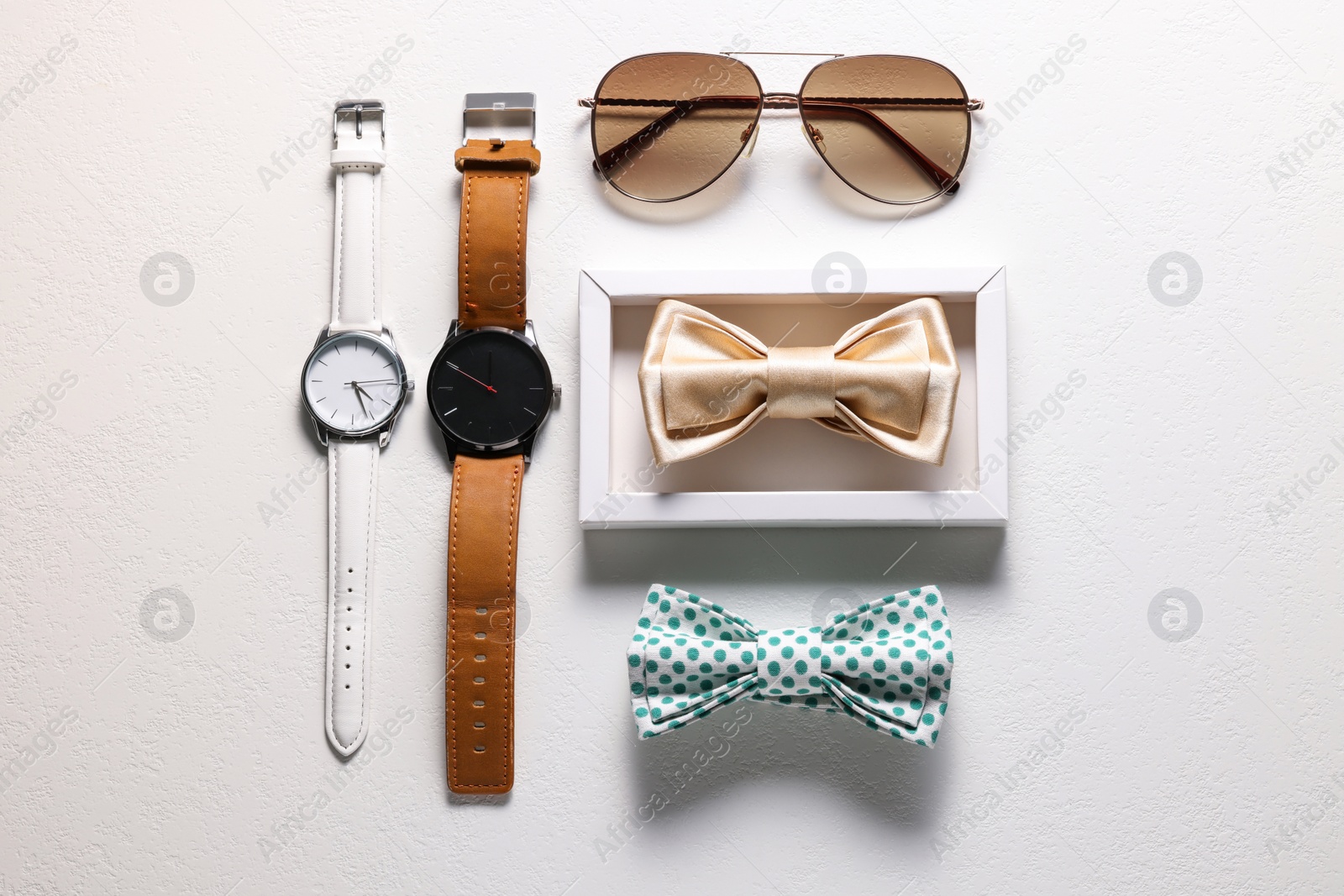 Photo of Stylish color bow ties, wristwatches and sunglasses on white background, flat lay