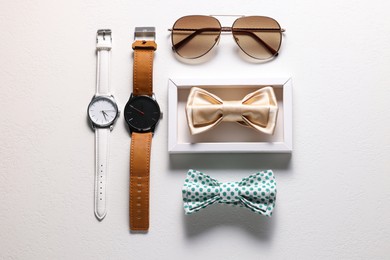 Photo of Stylish color bow ties, wristwatches and sunglasses on white background, flat lay
