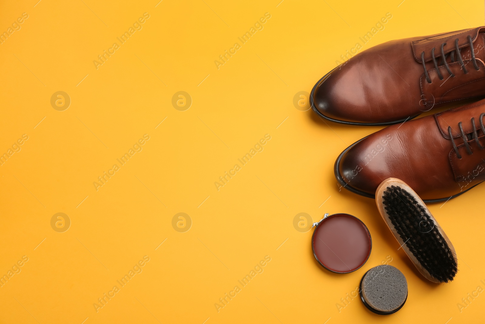Photo of Shoes care accessories and footwear on yellow background, flat lay. Space for text