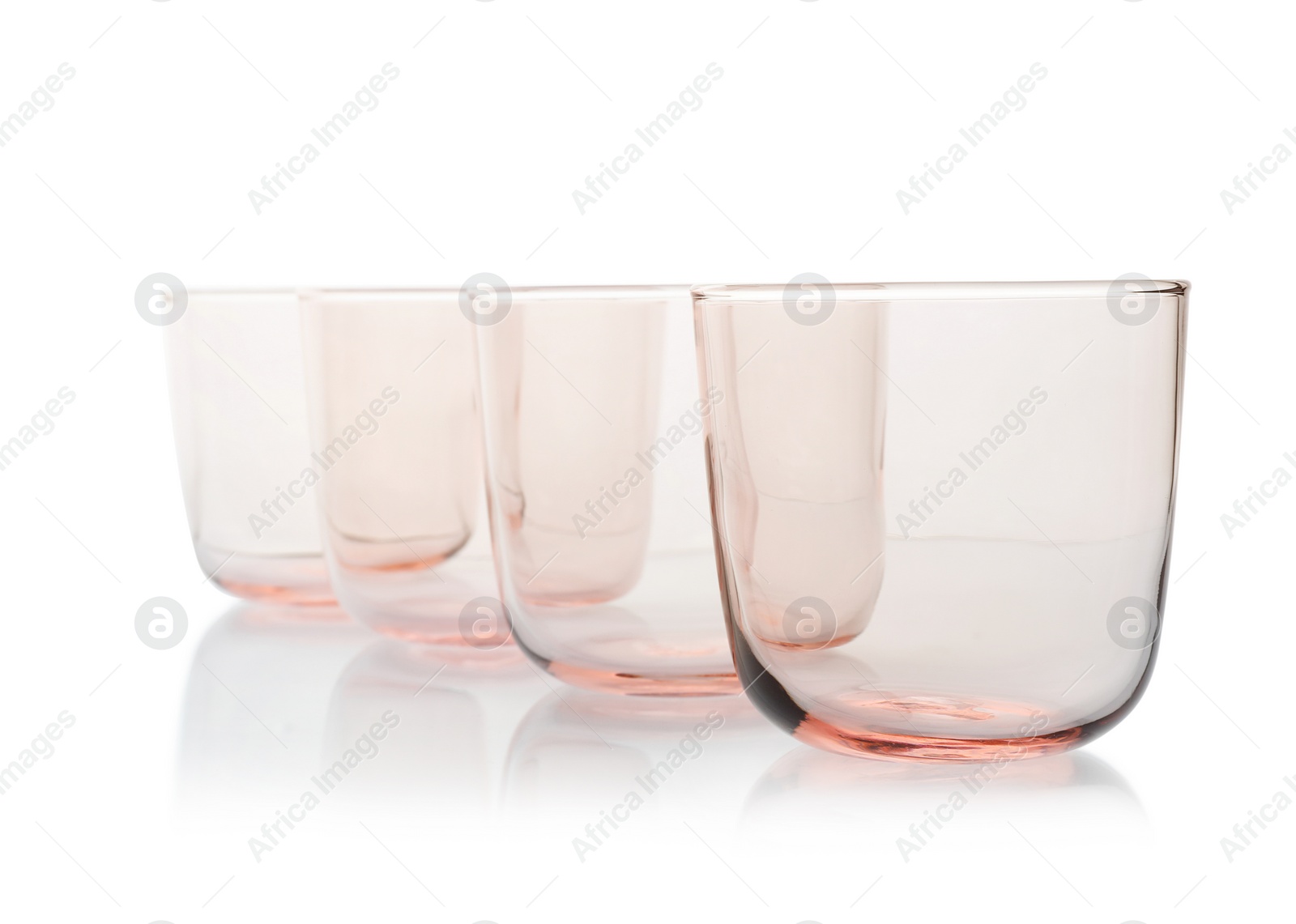 Photo of Empty elegant colorful whiskey glasses on white background