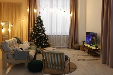 Wide TV set, furniture and Christmas tree in stylish room