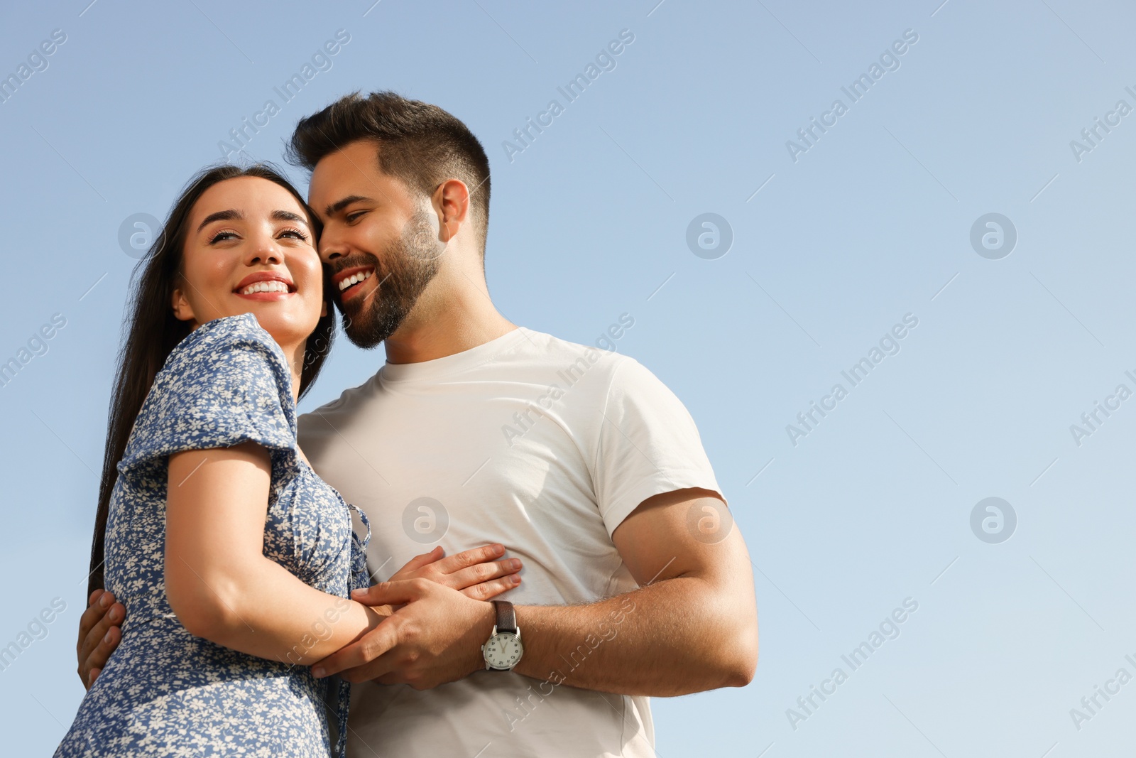 Photo of Romantic date. Beautiful couple spending time together against blue sky, low angle view with space for text