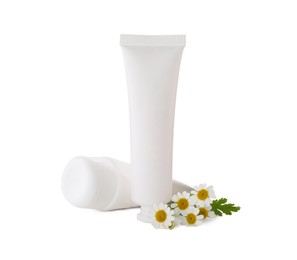 Photo of Tubes of hand cream and chamomiles on white background