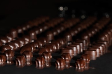 Many delicious chocolate candies on table. Production line