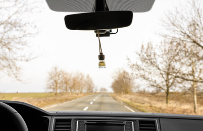 Air freshener hanging on rear view mirror in car
