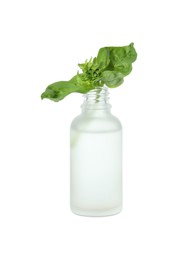Photo of Bottle of essential oil and basil isolated on white