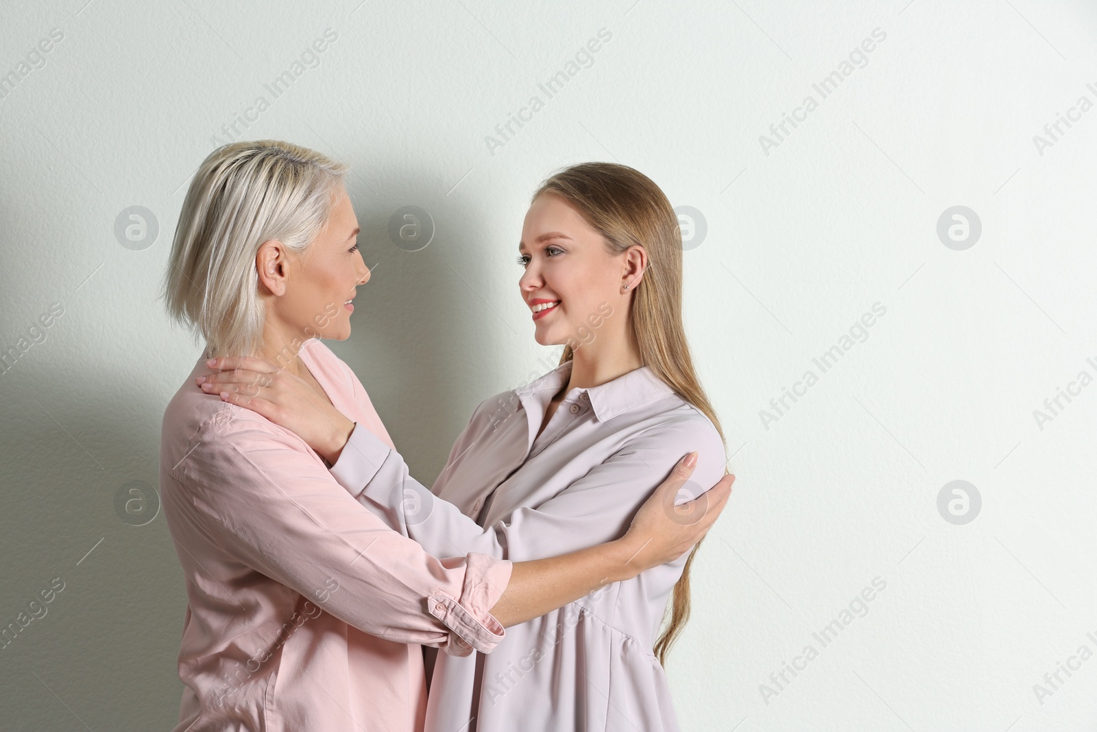 Photo of Mother and her adult daughter on white background