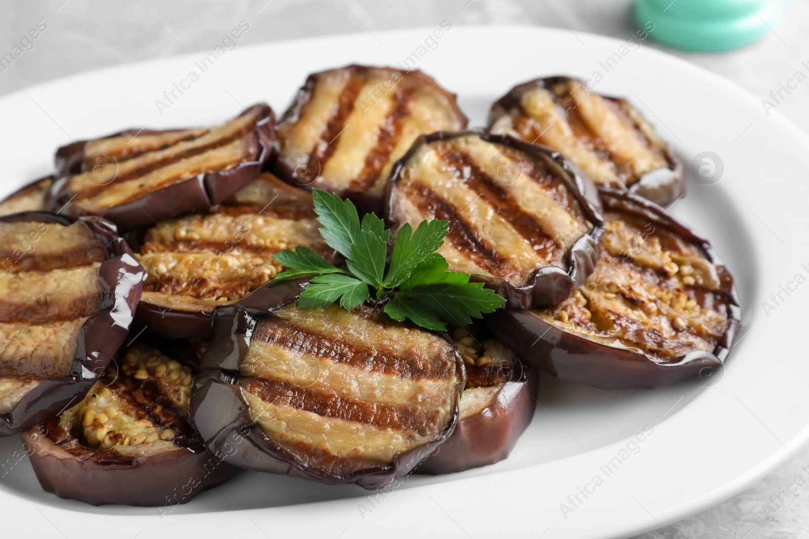 Photo of Delicious grilled eggplant slices on plate, closeup