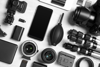 Flat lay composition with camera and video production equipment on light background