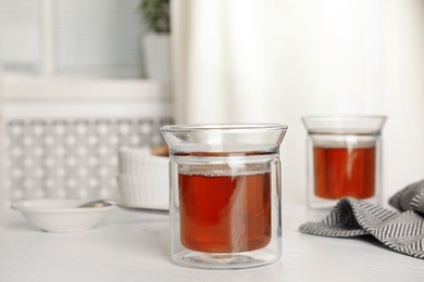 Glasses of hot fresh tea on table indoors