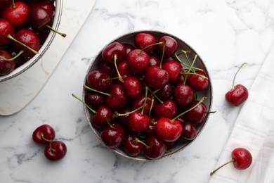 Fresh ripe cherries with water drops on white marble table, flat lay