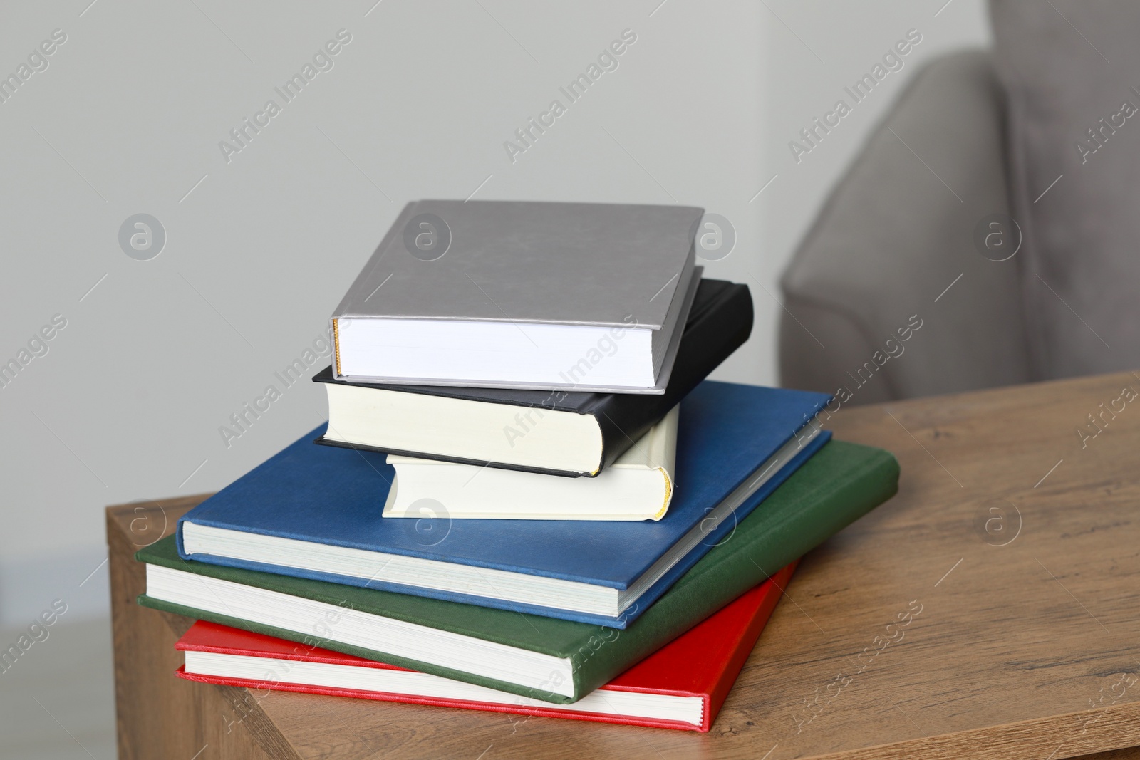 Photo of Stack of hardcover books on wooden table indoors