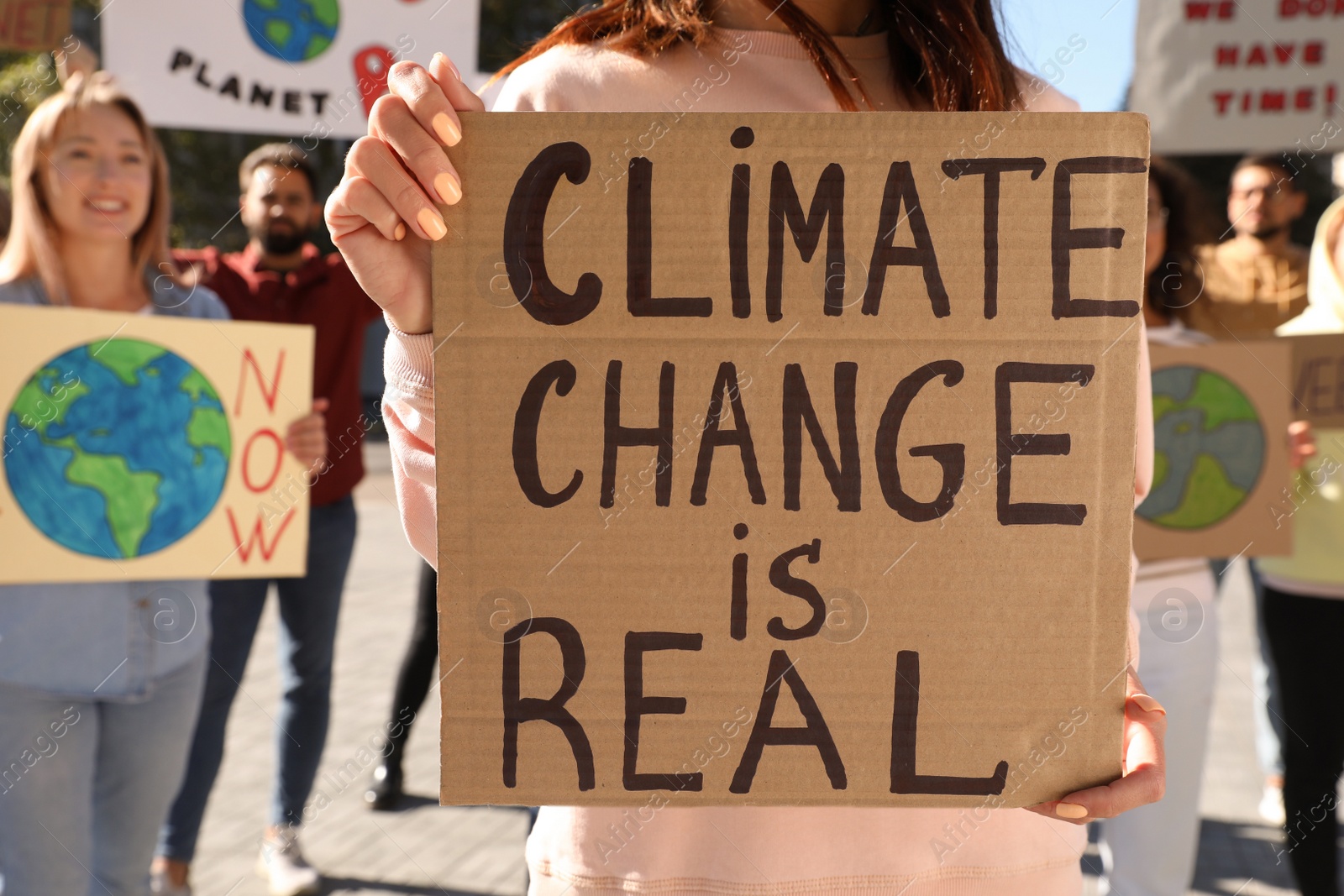Photo of Woman with poster protesting against climate change outdoors, closeup