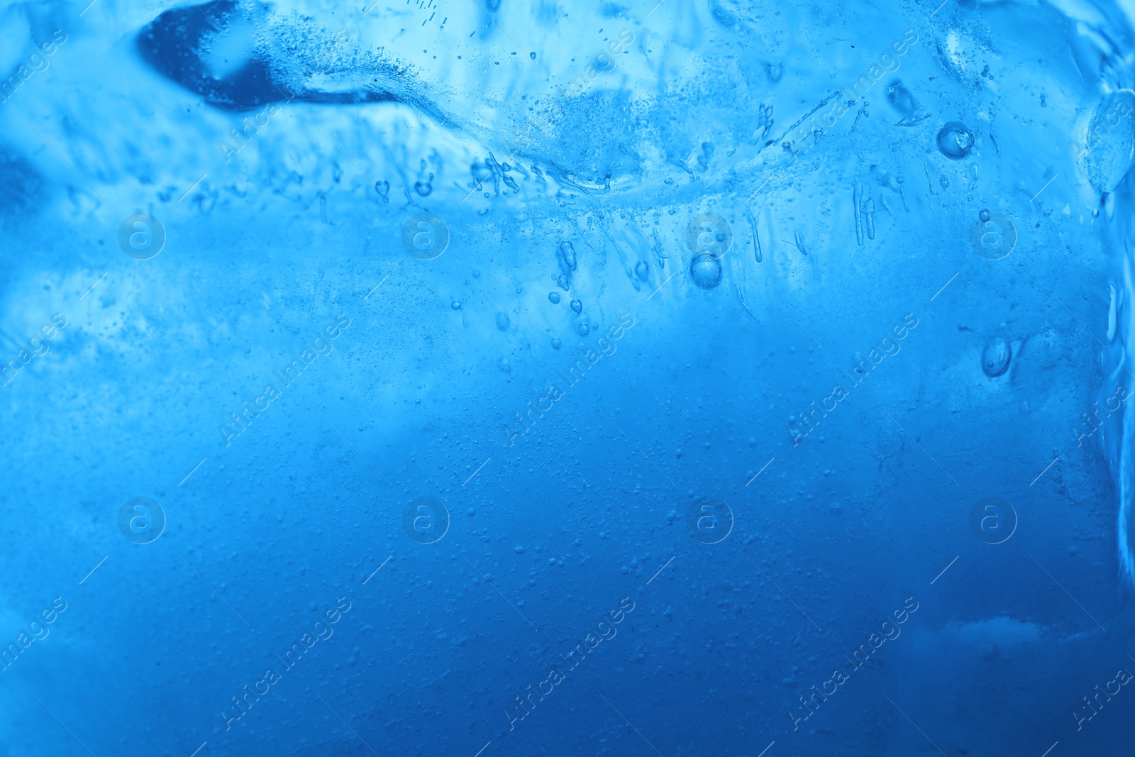 Photo of Closeup view of light blue crystal clear ice cube as background. Color tone effect