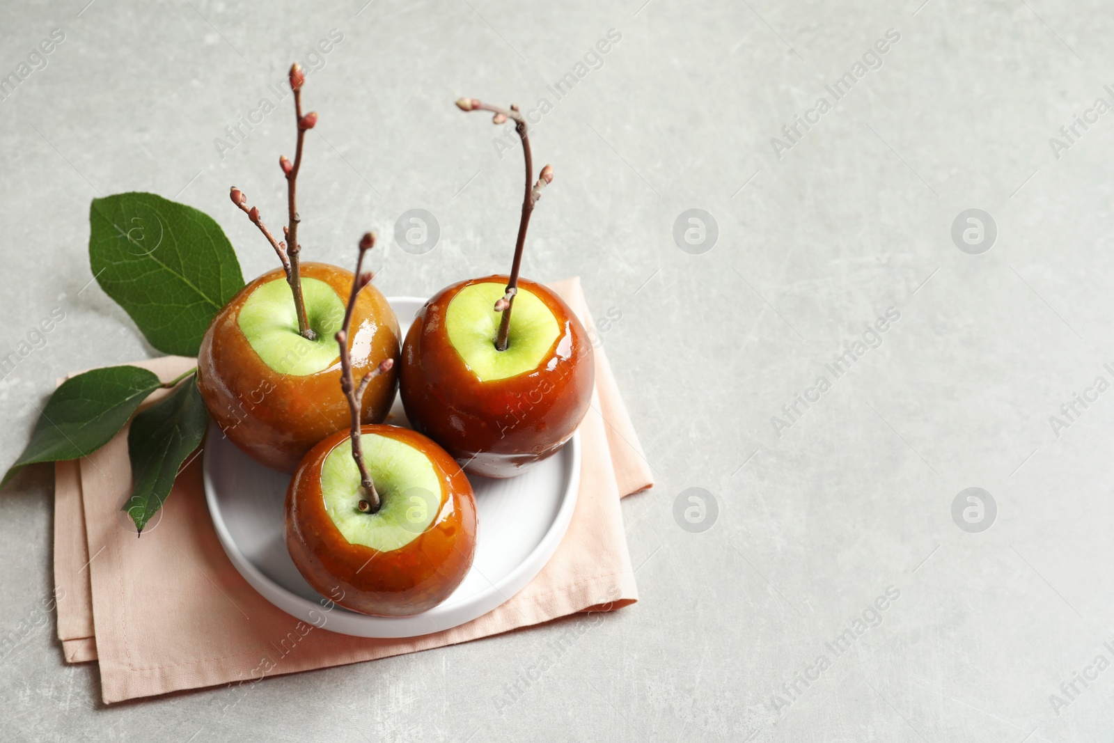 Photo of Plate with delicious green caramel apples on table